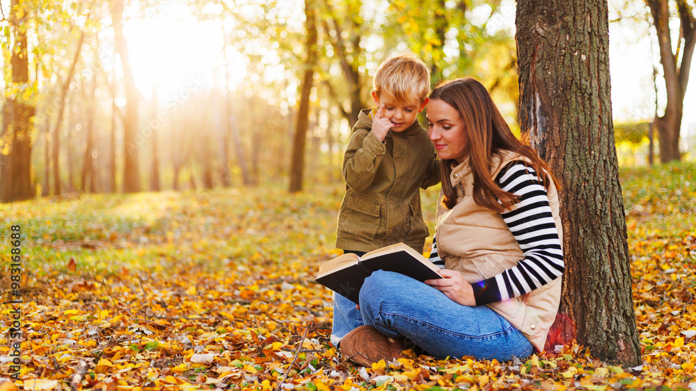 Mother and child reading book in autumn park Mother and child reading book in autumn park