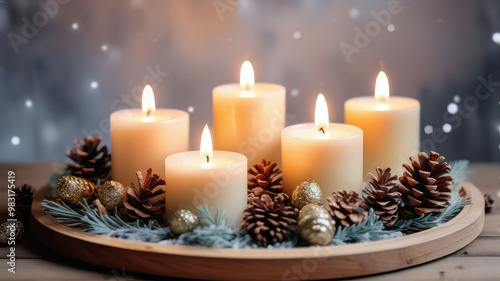 Burning Christmas candles with by pine branches and cones on a wooden table.