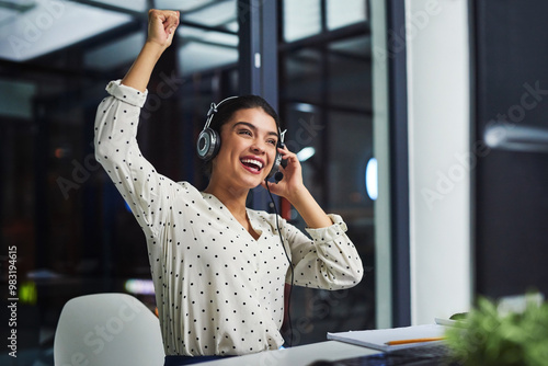 Woman, call center and smile with celebration, fist and bonus for telemarketing at night in office. Person, agent and consultant with cheers for target, goals and customer service with sales lead photo