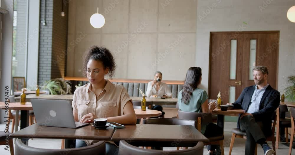 Young African American Female Freelancer using Laptop, Working from a Cafe Young African American Female Freelancer using Laptop, Working from a Cafe
