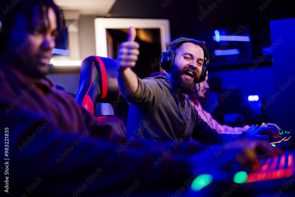 Excited gamer with headset giving thumbs up for level up in video game Excited gamer with headset giving thumbs up for level up in video game