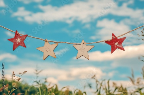 Colorful stars hanging outdoors against a blue sky with clouds on a sunny day