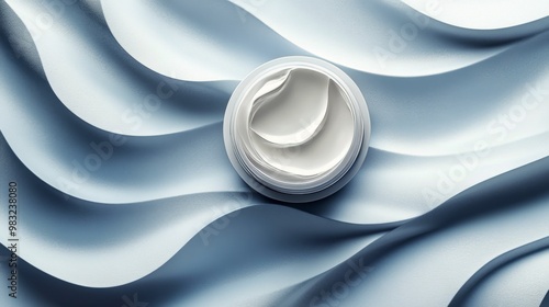 Cream container on soft blue waves showcasing skincare product elegance in br...
