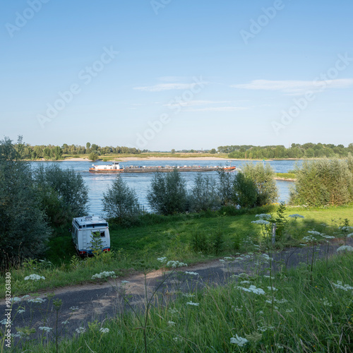 camper van on bank of river waal near nijmegen with passing ships photo