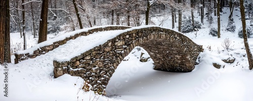 A stone bridge in a snowy woodland, its sturdy structure unaffected by the weight of the snow, providing a safe and scenic crossing for winter walkers