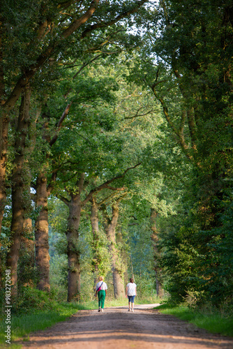 two women walk on dirt road in dutch area achtyerhoek near doetinchem photo