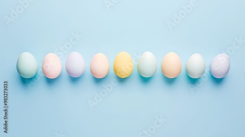 A row of Easter eggs dyed in various pastel colors on a light blue background