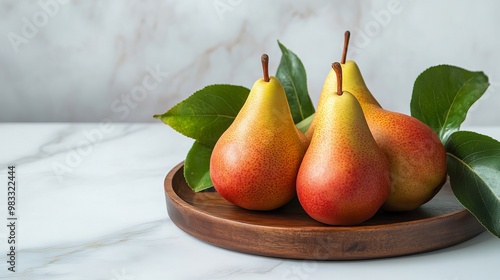 Vibrant Arrangement of Three Ripe Forelle Pears with Green Leaves on a Rustic Wooden Tray Against a Chic White Marble Background—A Celebration of Healthy Eating photo