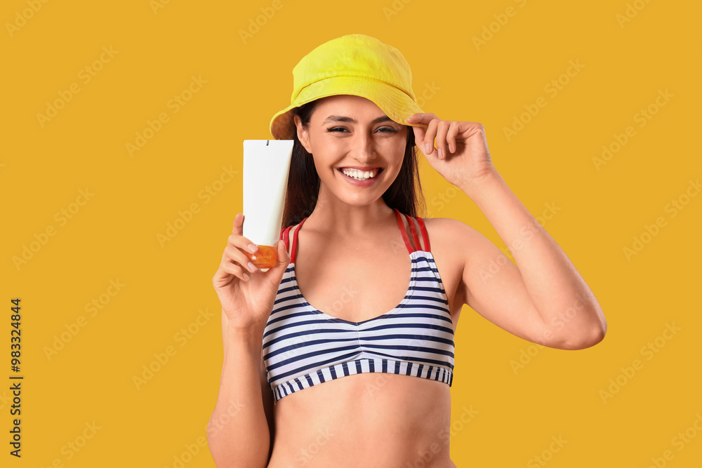 Young woman with sunscreen cream on yellow background Young woman with sunscreen cream on yellow background