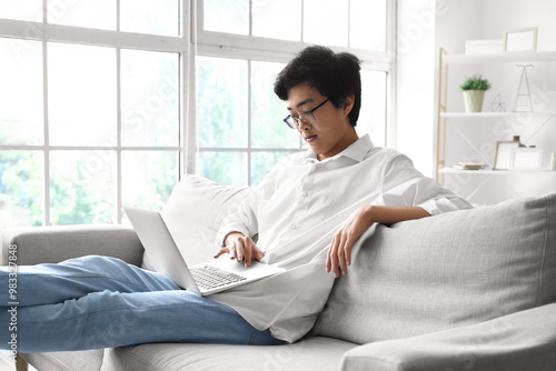 Young Asian man using lapto...
