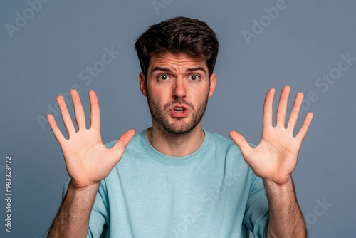 Young Man with Shocked Expression, Holding Out Both Hands photo