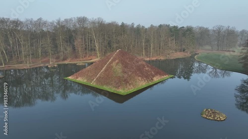 Drone view of Prince Pueckler's Pyramid Grave on the lake in Branitzer Park on a foggy autumn day photo