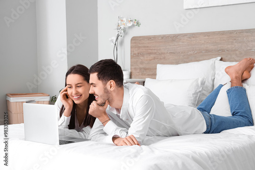 Young couple lying with lap...