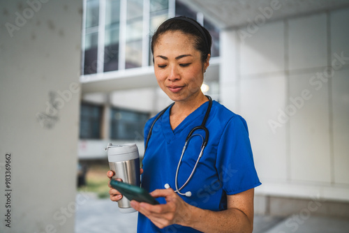 japanese doctor stand and use cellphone in front of modern building