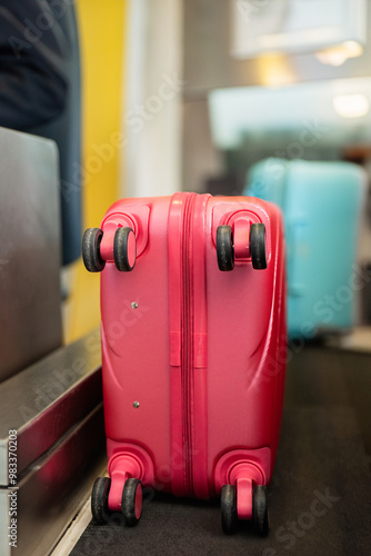 Bright pink suitcase standing in airport waiting area photo