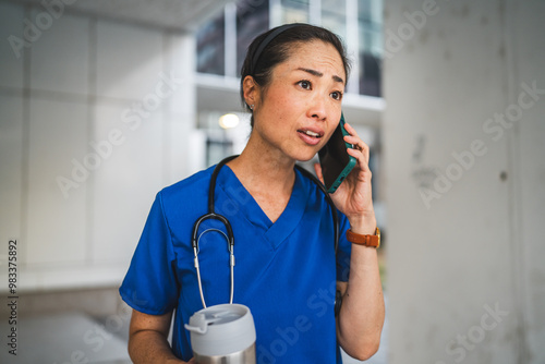 angry mature japanese doctor stand and talk on mobile phone photo