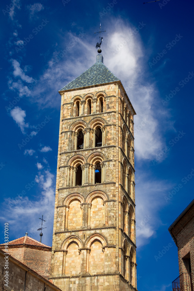 Fototapeta premium Romanesque tower of the church of San Esteban (12th century), in Plaza de San Esteban in Segovia, Castilla y Leon, Spain, perspective view with intense blue sky