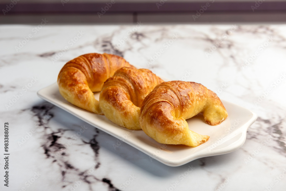 Fresh sweet and salty golden butter croissants alone and filled with ham and cheese on white sheet Fresh sweet and salty golden butter croissants alone and filled with ham and cheese on white sheet