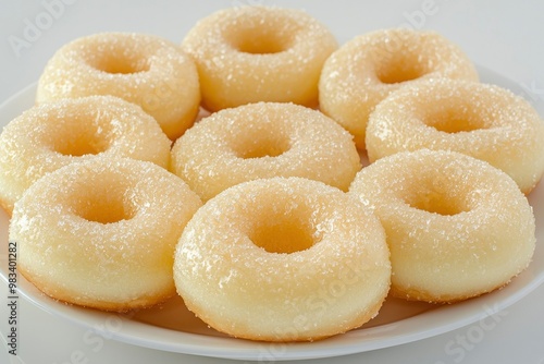 A plate of eight sugared donuts