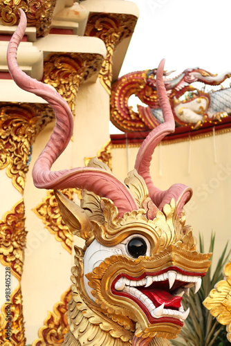 A golden statue of a horned dragon, dog, lion, guardian, deity, spirit, mythological creature next to the entrance to the Wat Muen Tum, Muentoom Temple, Chiang Mai, Thailand photo