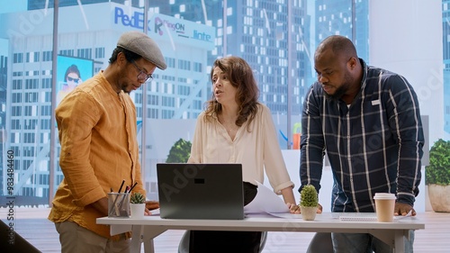 Business professionals and a real estate agent engage in a planning session, discussing the layout and design of a new office space based on detailed blueprints. Property investment. Camera A. photo