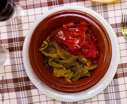 There is portion of escalibada on plate - traditional vegetable dish of stewed seasonal vegetables eggplant, pepper, onion, tomatoes with thick spicy gravy photo