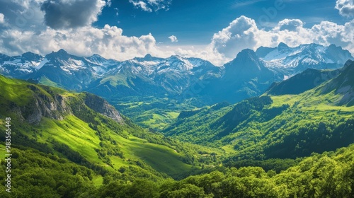 A panoramic view of the French Pyrenees, with lush green valleys and snow-capped peaks.