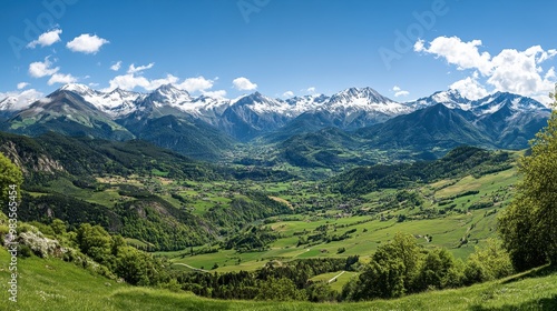 A panoramic view of the French Pyrenees, with lush green valleys and snow-capped peaks.