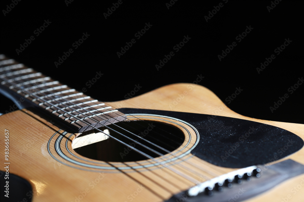Fototapeta premium Acoustic guitar close-up on black background