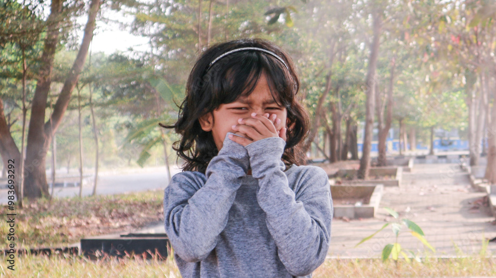 A little girl is covering her nose because of air pollution A little girl is covering her nose because of air pollution