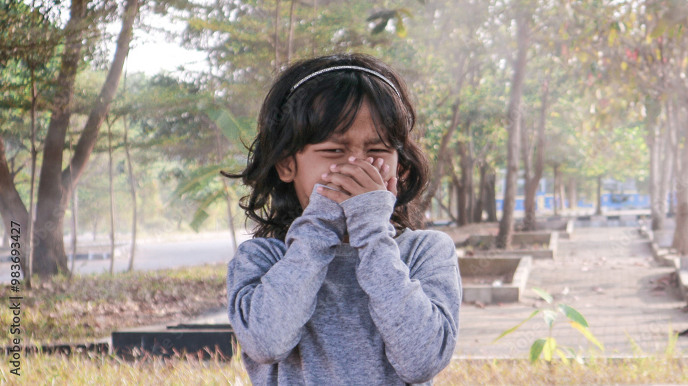A little girl is covering her nose because of air pollution A little girl is covering her nose because of air pollution