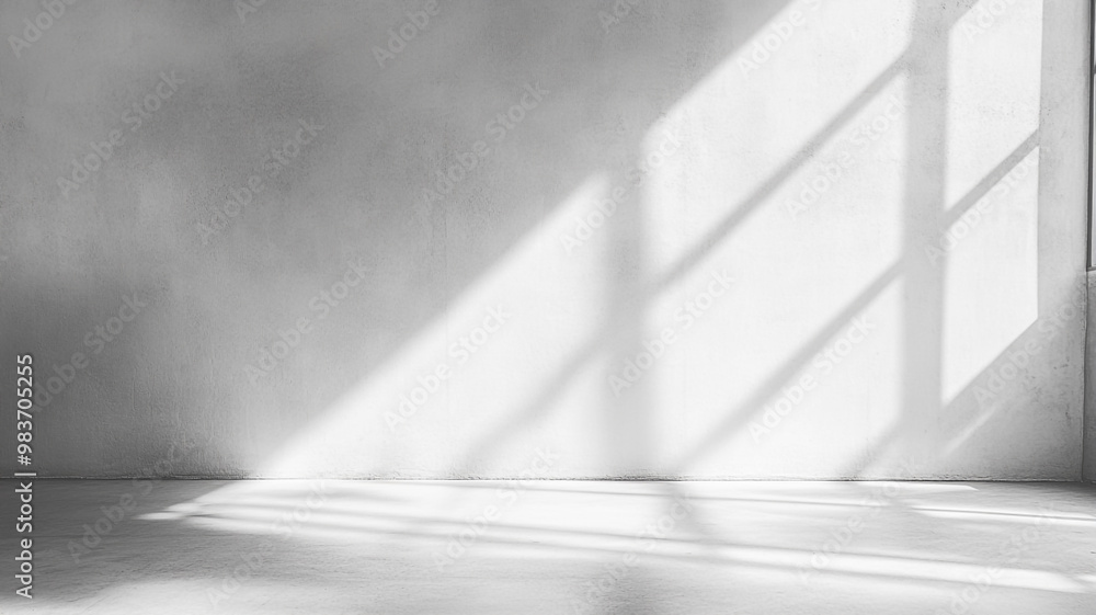 Soft sunlight casts geometric shadows on a minimalist gray wall in a quiet indoor space Soft sunlight casts geometric shadows on a minimalist gray wall in a quiet indoor space