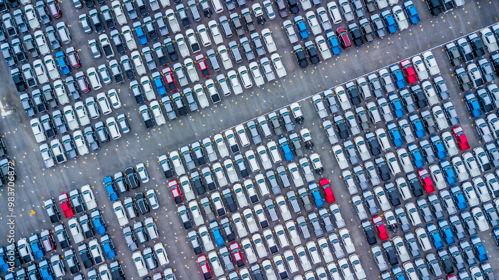 Fototapeta premium Aerial view new cars lined up in the port for import and export, Top view of new cars lined up automobile factory global logistic import export, New cars logistic to dealership for sale.