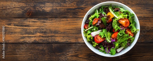 Wallpaper Mural Fresh mixed green salad with tomato and red onion served in a bowl on rustic wooden table. Healthy vegetarian meal option. Torontodigital.ca