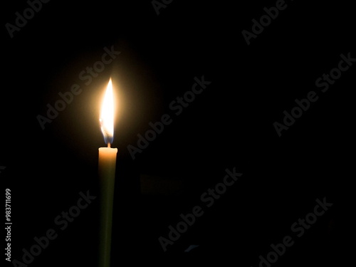 The candlelight glows in the darkness, making it a perfect background image.