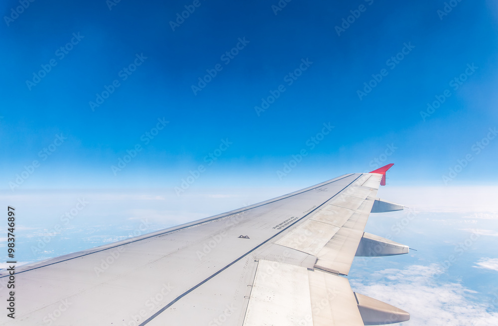 View from the airplane window at a beautiful cloudy sky and the airplane wing View from the airplane window at a beautiful cloudy sky and the airplane wing