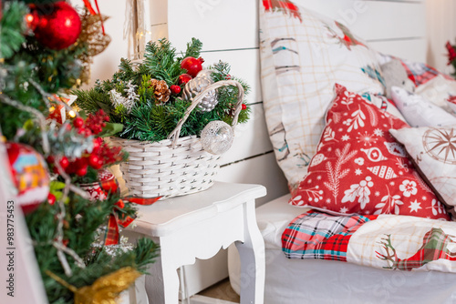 Interior of festive bedroom with comfortable bed and Christmas tree. checkered blanket. Christmas home decoration. Christmas tree, garland with lights, gifts. Winter holidays