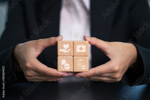  Woman's hand arrange  shape with clinic or hospital sign on wooden cube block . Wellbeing, World Health Day concept