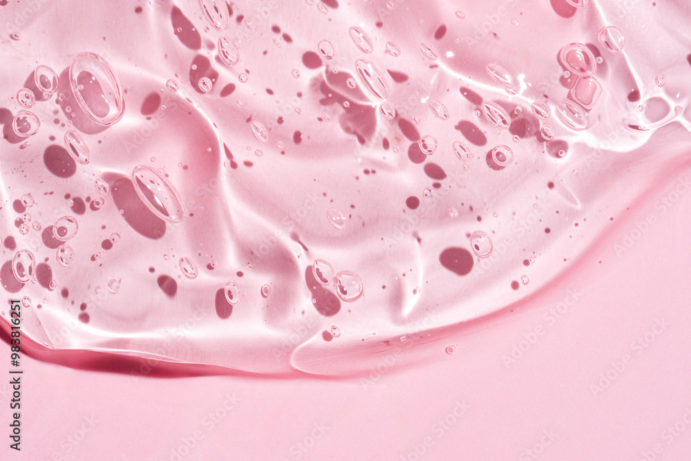 Gel serum texture background. pink skin care liquid swirl. Clear cosmetic cream with bubbles closeup on pink Gel serum texture background. pink skin care liquid swirl. Clear cosmetic cream with bubbles closeup on pink