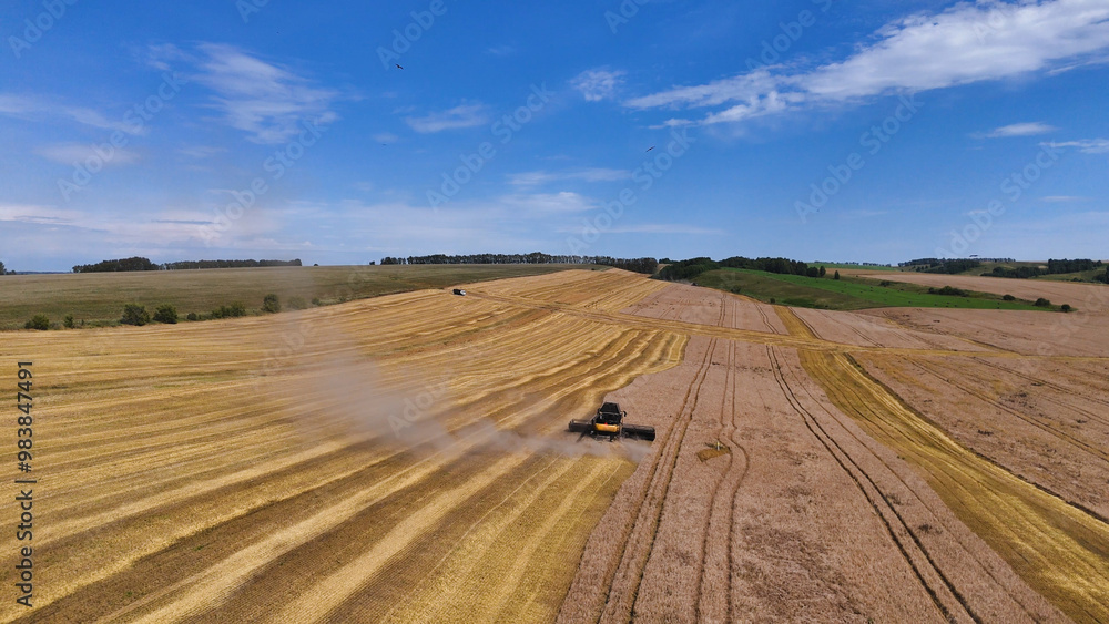 a combine harvester in a wheat field performs harvesting operations a combine harvester in a wheat field performs harvesting operations
