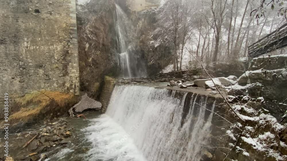 Waterfall and dam in winter with snowfall. Beautiful winter scene - static shot Waterfall and dam in winter with snowfall. Beautiful winter scene - static shot