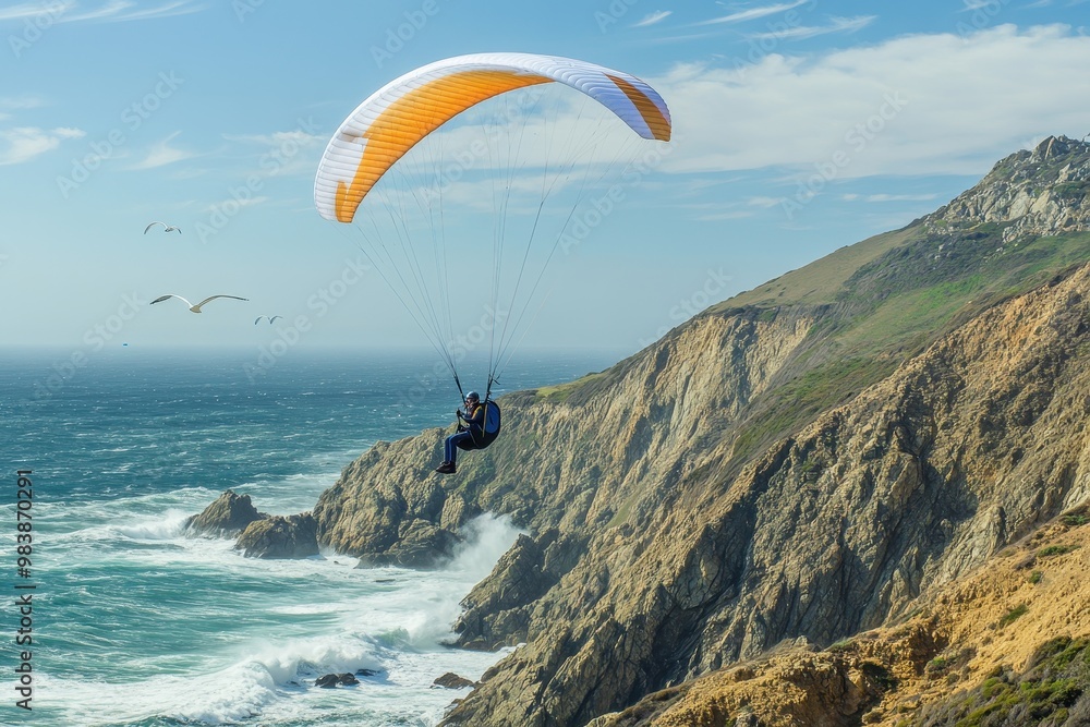A paraglider soaring over a rugged coastline with waves crashing below. A paraglider soaring over a rugged coastline with waves crashing below.