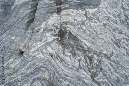 A detailed close-up reveals the unique swirls and veins of gray marble, highlighting its natural beauty and intricate patterns suitable for design