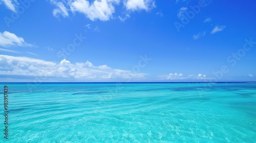 A beautiful scene of the blue ocean against the blue sky background. The ocean stretches out as far as the eye can see, with its surface glistening in the sunlight