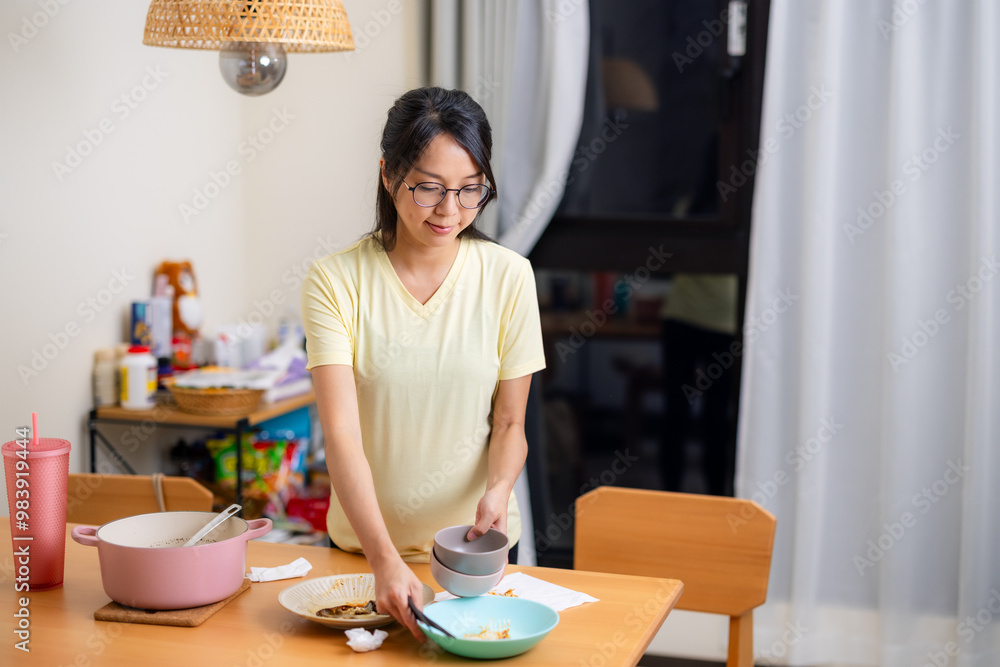 Pregnant woman do housework at home after dinner Pregnant woman do housework at home after dinner