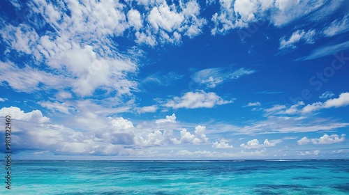 A beautiful scene of the blue ocean against the blue sky background. The ocean stretches out as far as the eye can see, with its surface glistening in the sunlight