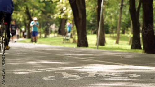 Wallpaper Mural A peaceful weekend morning scene featuring a crowd of people exercising and riding bikes through a lush park. Soft sunlight filters through trees, creating a calm, active atmosphere Torontodigital.ca