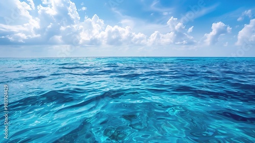 A beautiful scene of the blue ocean against the blue sky background. The ocean stretches out as far as the eye can see, with its surface glistening in the sunlight