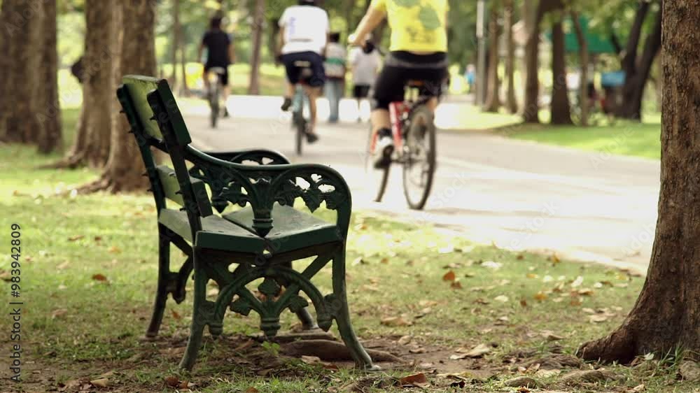 A peaceful weekend morning scene featuring a crowd of people exercising and riding bikes through a lush park. Soft sunlight filters through trees, creating a calm, active atmosphere A peaceful weekend morning scene featuring a crowd of people exercising and riding bikes through a lush park. Soft sunlight filters through trees, creating a calm, active atmosphere