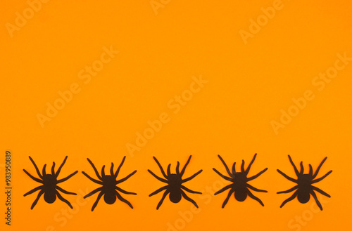 Black spiders on a vibrant orange background create a striking visual contrast in autumn photo